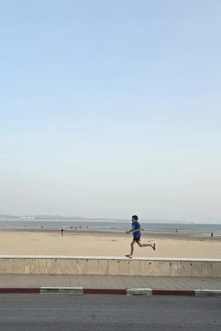 Marocco, Essaouira, bambino che corre lungo la spiaggia